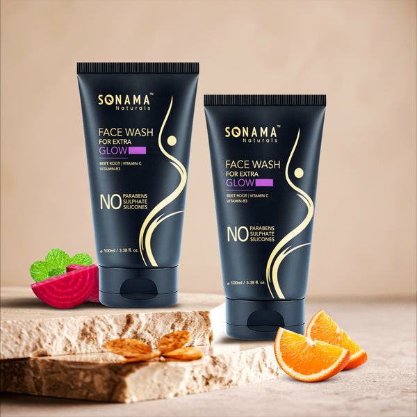 Two Sonama Naturals face wash tubes on a wooden surface, surrounded by fruits and vegetables.