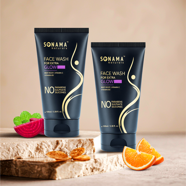 Two Sonama Naturals face wash tubes on a wooden surface, surrounded by fruits and vegetables.