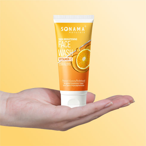 Bright orange Vitamin C face wash tube displayed on a vibrant yellow background for glowing skin.